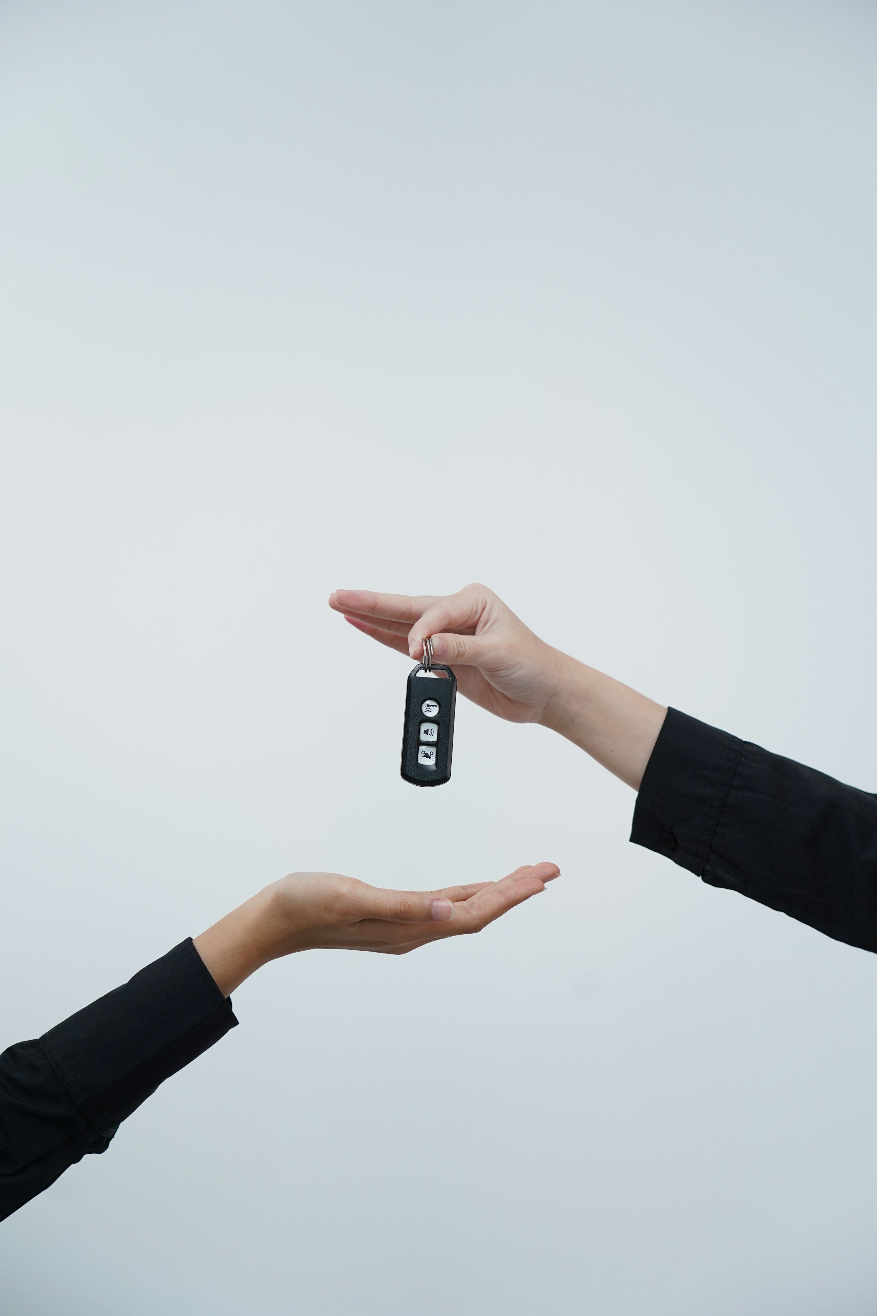 One hand passing a car key to another